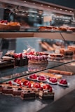 strawberry and blackberry on clear glass display counter