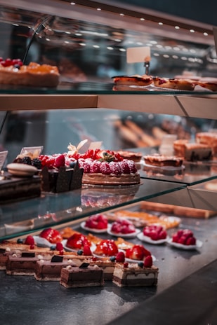 strawberry and blackberry on clear glass display counter