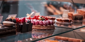 strawberry and blackberry on clear glass display counter