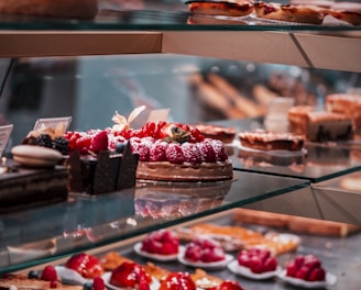 strawberry and blackberry on clear glass display counter