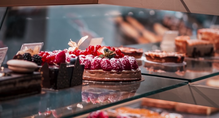 strawberry and blackberry on clear glass display counter