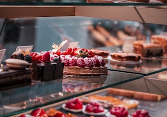 strawberry and blackberry on clear glass display counter