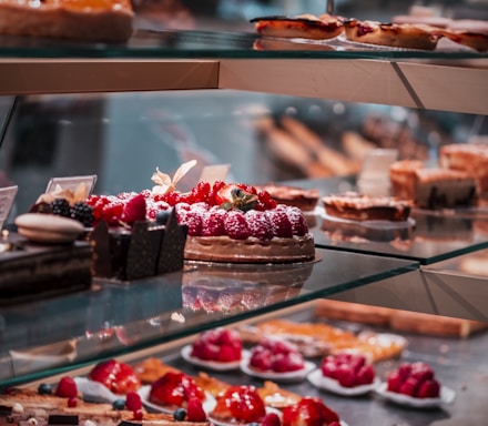 strawberry and blackberry on clear glass display counter