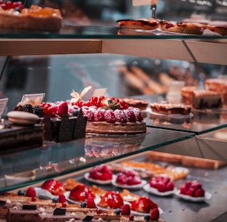 strawberry and blackberry on clear glass display counter