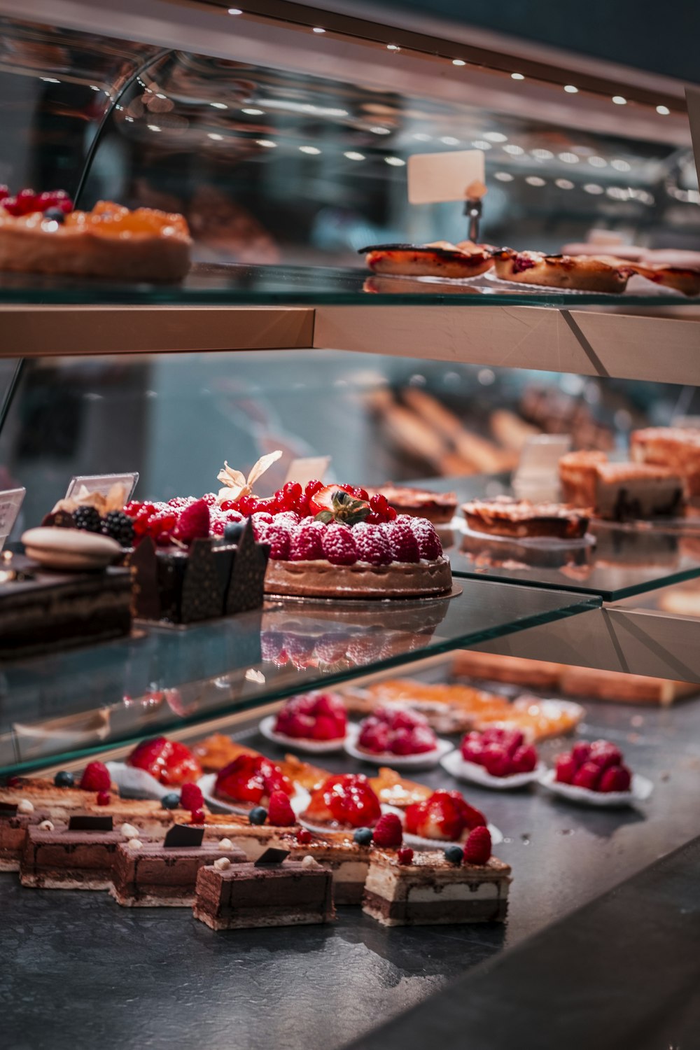 strawberry and blackberry on clear glass display counter