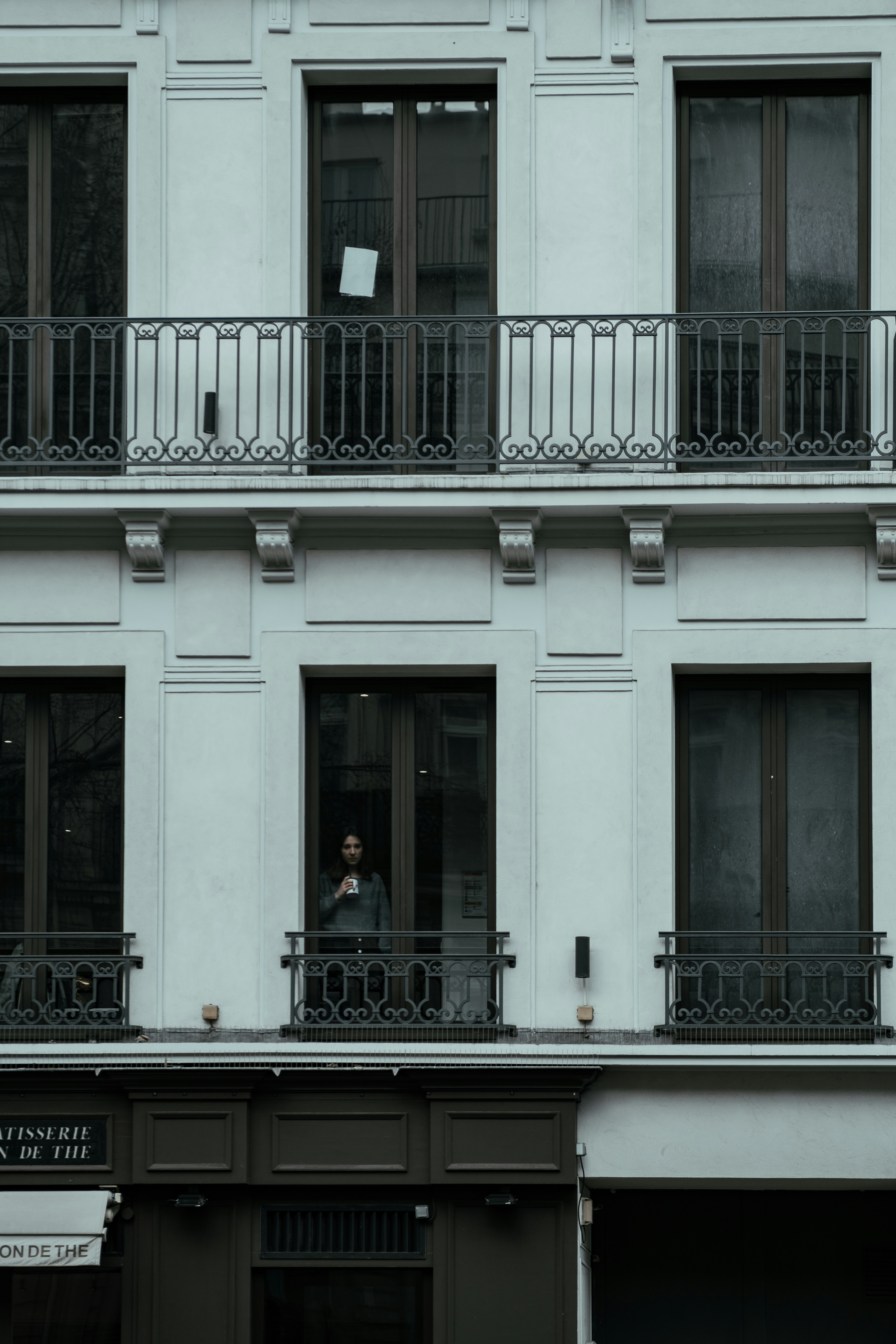 people sitting on bench in front of white concrete building during daytime