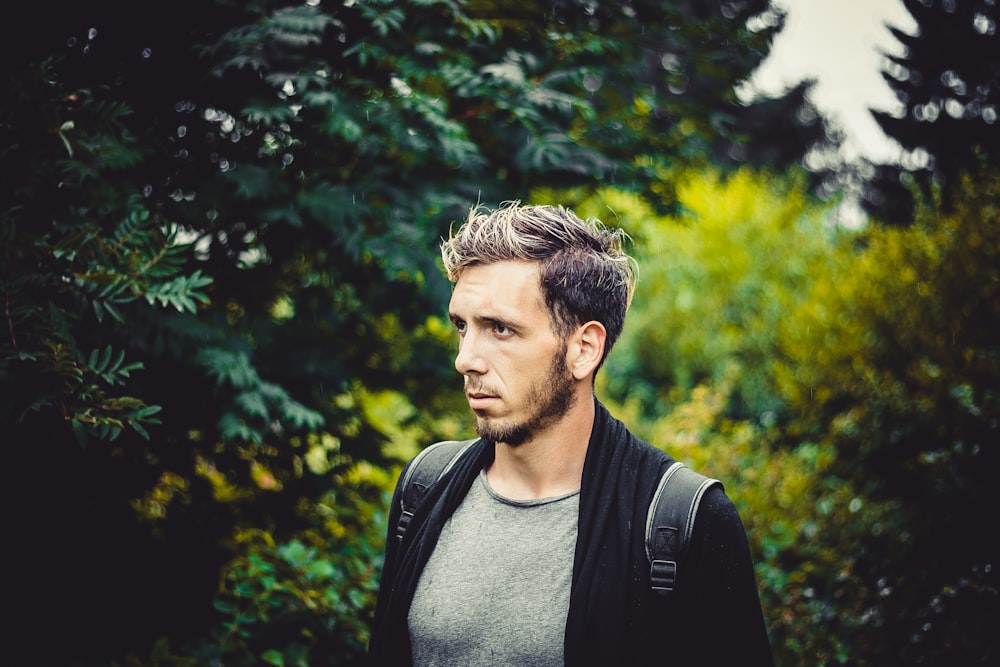 man in gray crew neck shirt and black backpack