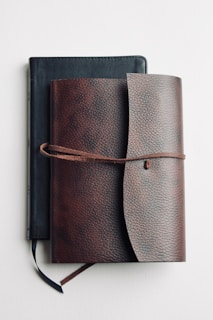 brown leather long wallet on white table