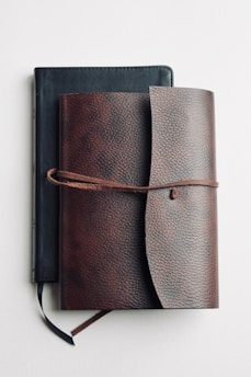 brown leather long wallet on white table