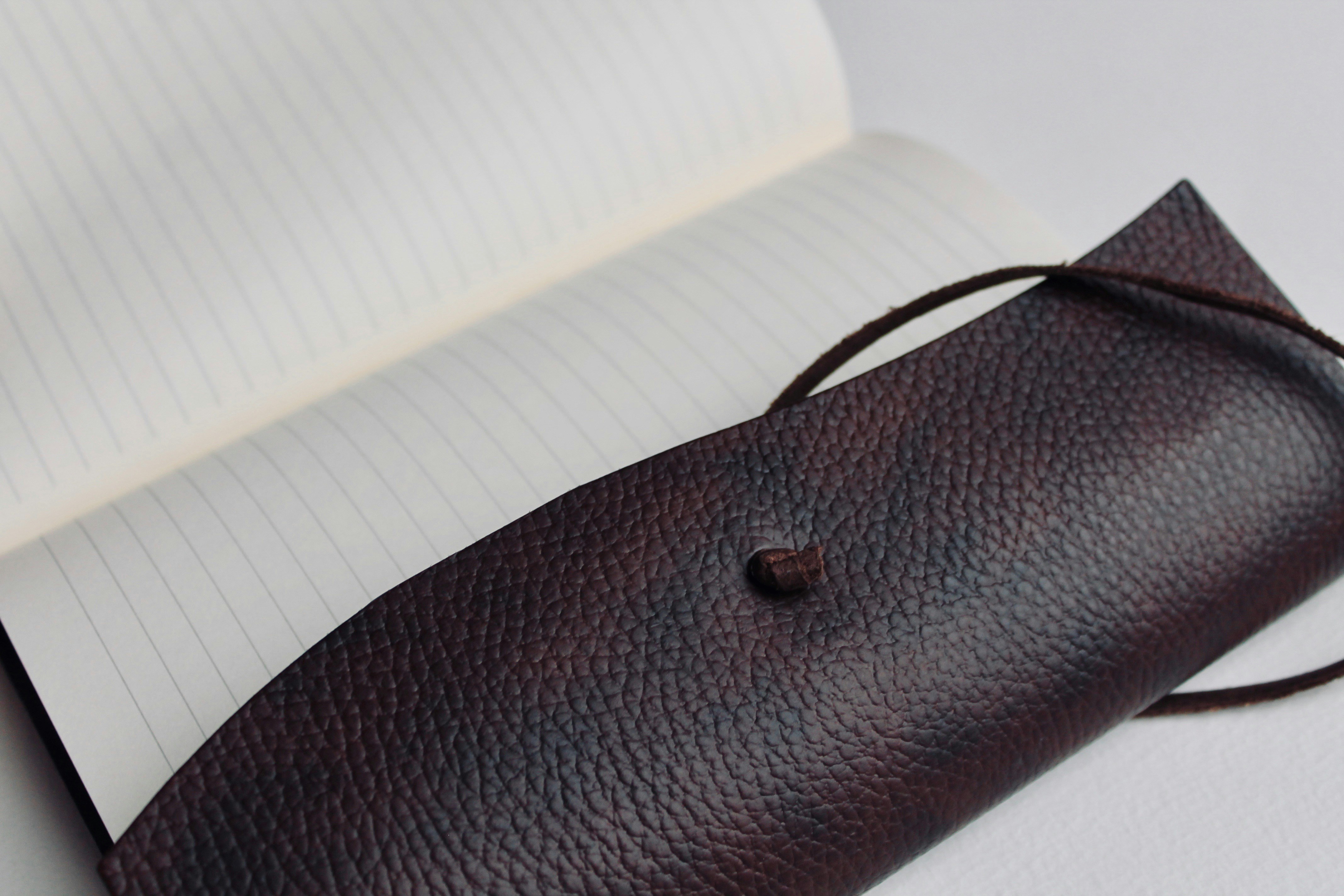 a pen case sitting on top of an open notebook