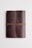 A closed leather notebook with a textured surface and a wraparound strap, lying on a plain white background.