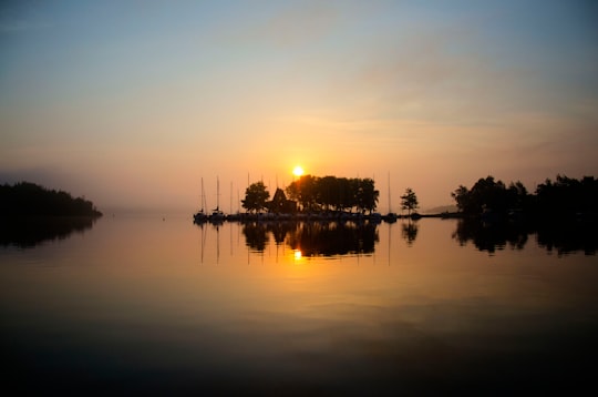 silhouette of trees on body of water during sunset in Sudbury Canada