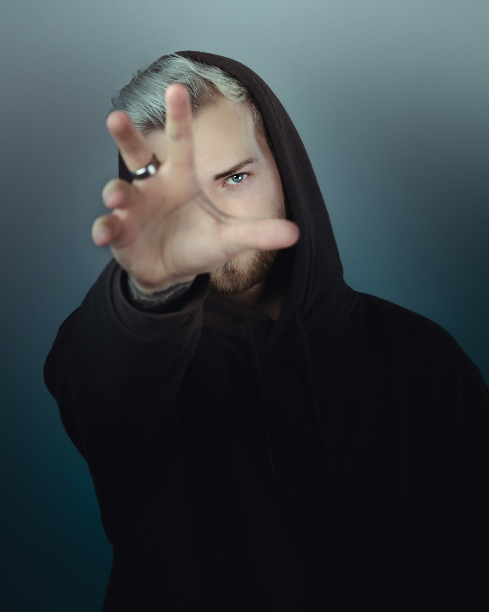 man in black hoodie reaching out his hand