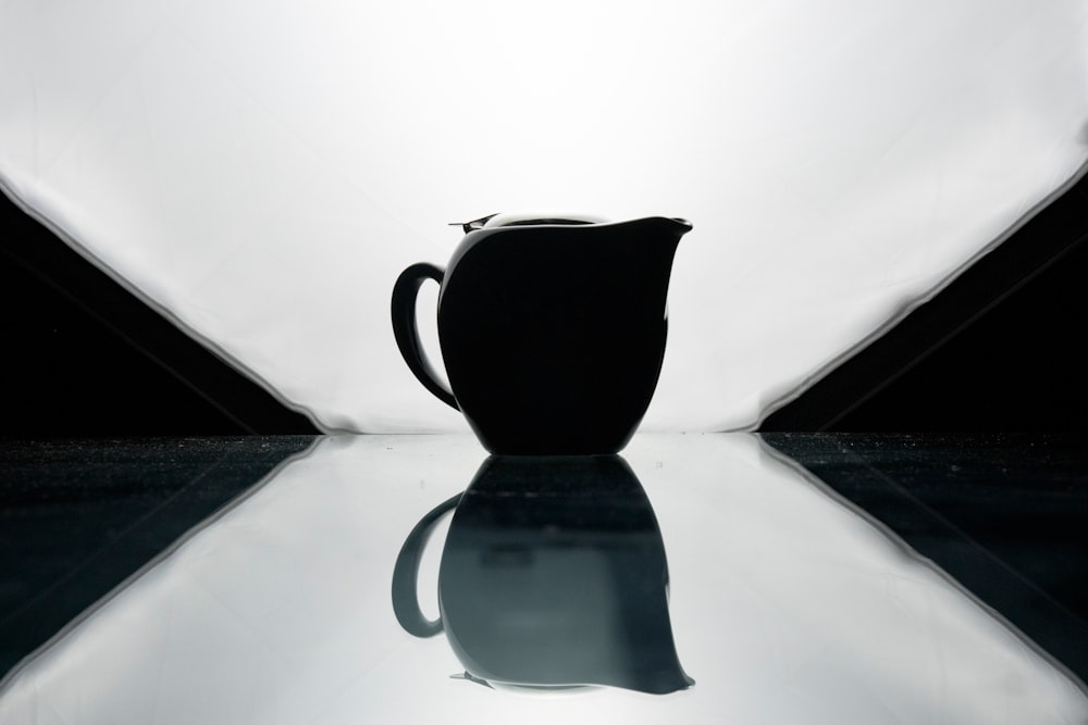 black ceramic teapot on white textile