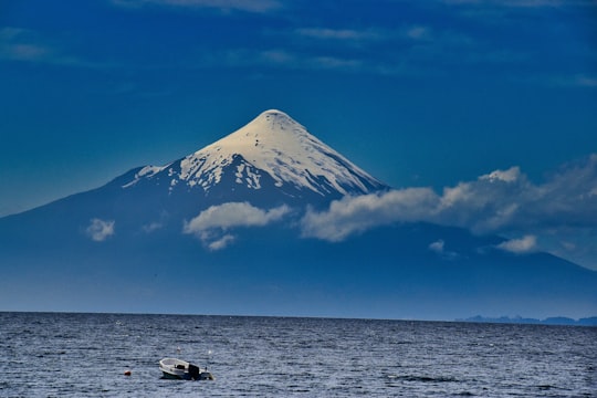 white boat on sea near snow covered mountain under blue sky during daytime in Puerto Varas Chile