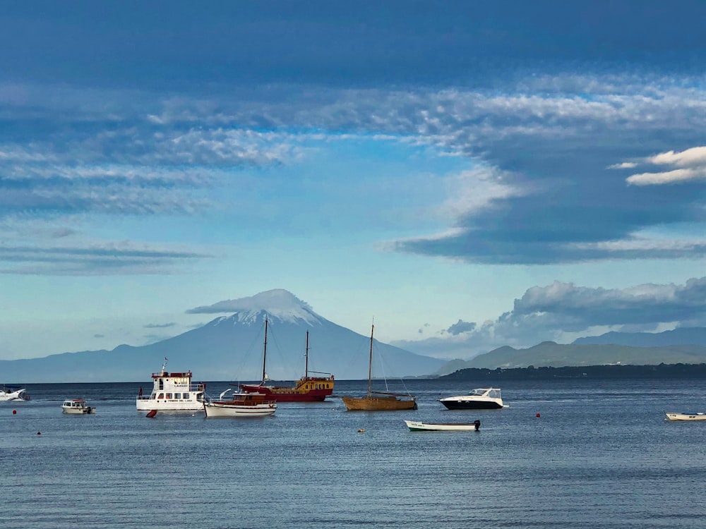 white and brown boat on sea under blue sky and white clouds during daytime