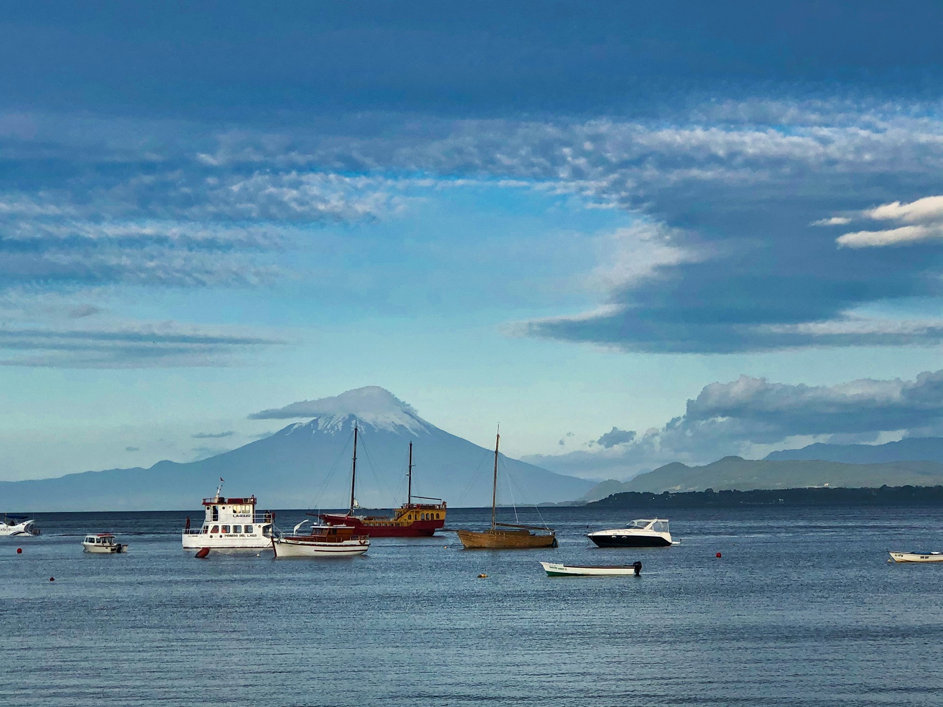 white and brown boat on sea under blue sky and white clouds during daytime