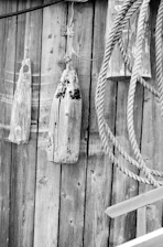 A close-up of a tide chart pinned on a rustic bulletin board with a nautical map in the background.