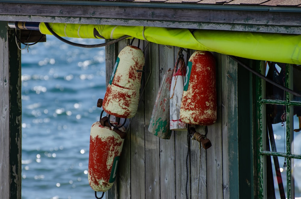 red and white bottles on green wooden fence