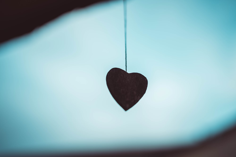 heart shaped black pendant on white surface