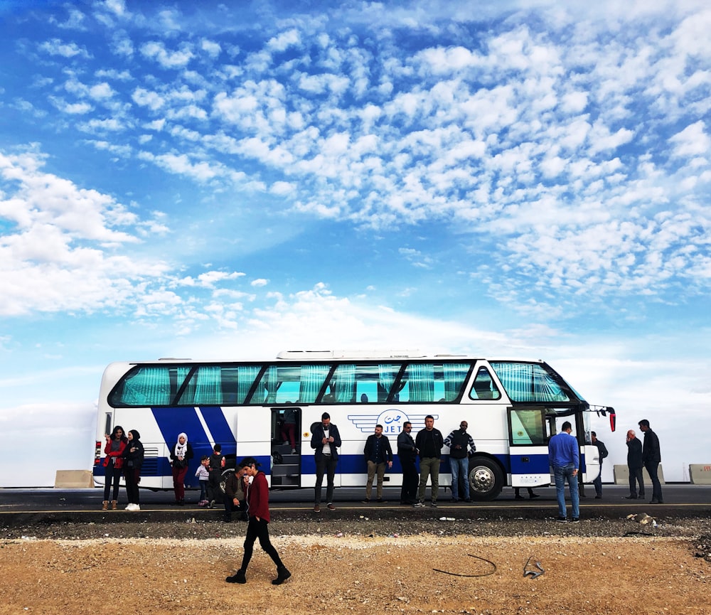 people standing near blue bus during daytime