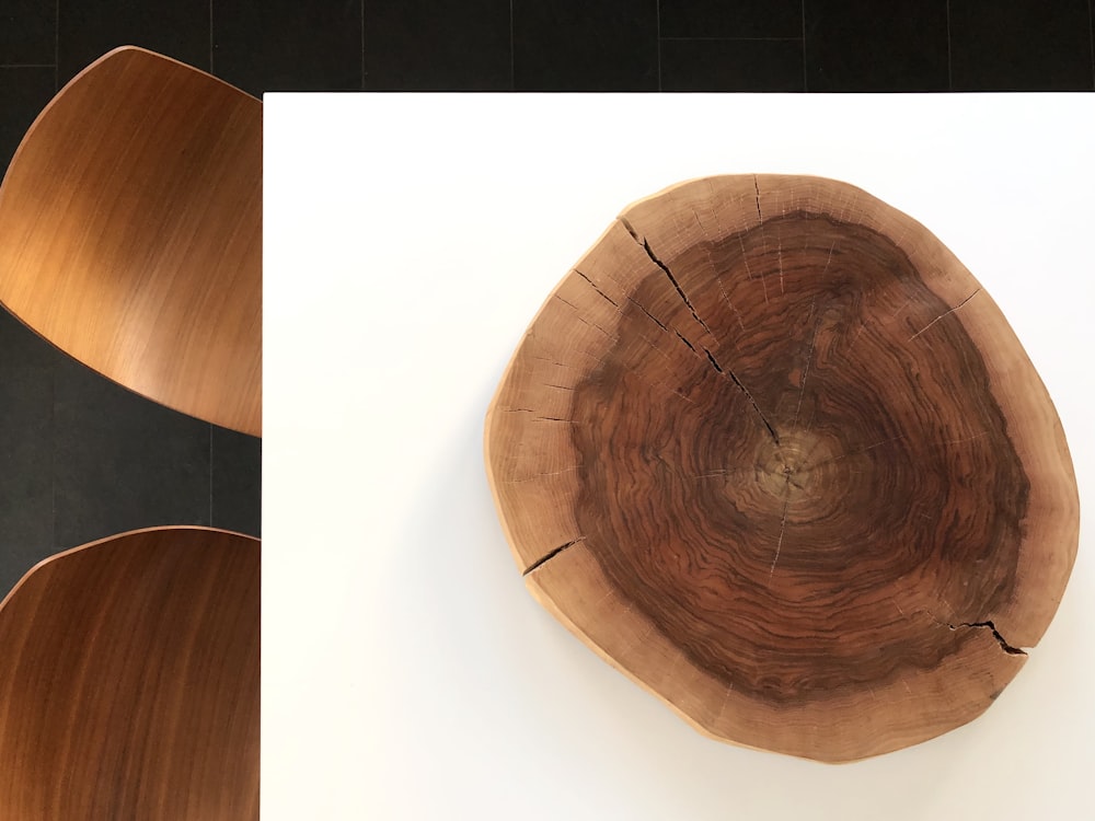 白い床タイルに茶色の木製の丸いテーブル