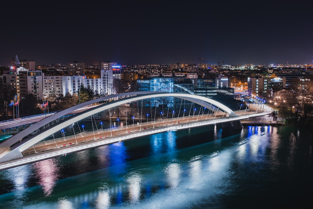 a bridge over a body of water with a city in the background