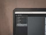 A computer monitor displays Adobe Lightroom Classic with a visible navigation panel on the left side. The interface includes options like Navigator, Presets, Snapshots, History, and Collections. A dark theme is applied, with a close-up focus on the top part of the screen, emphasizing the menu options and the title bar.