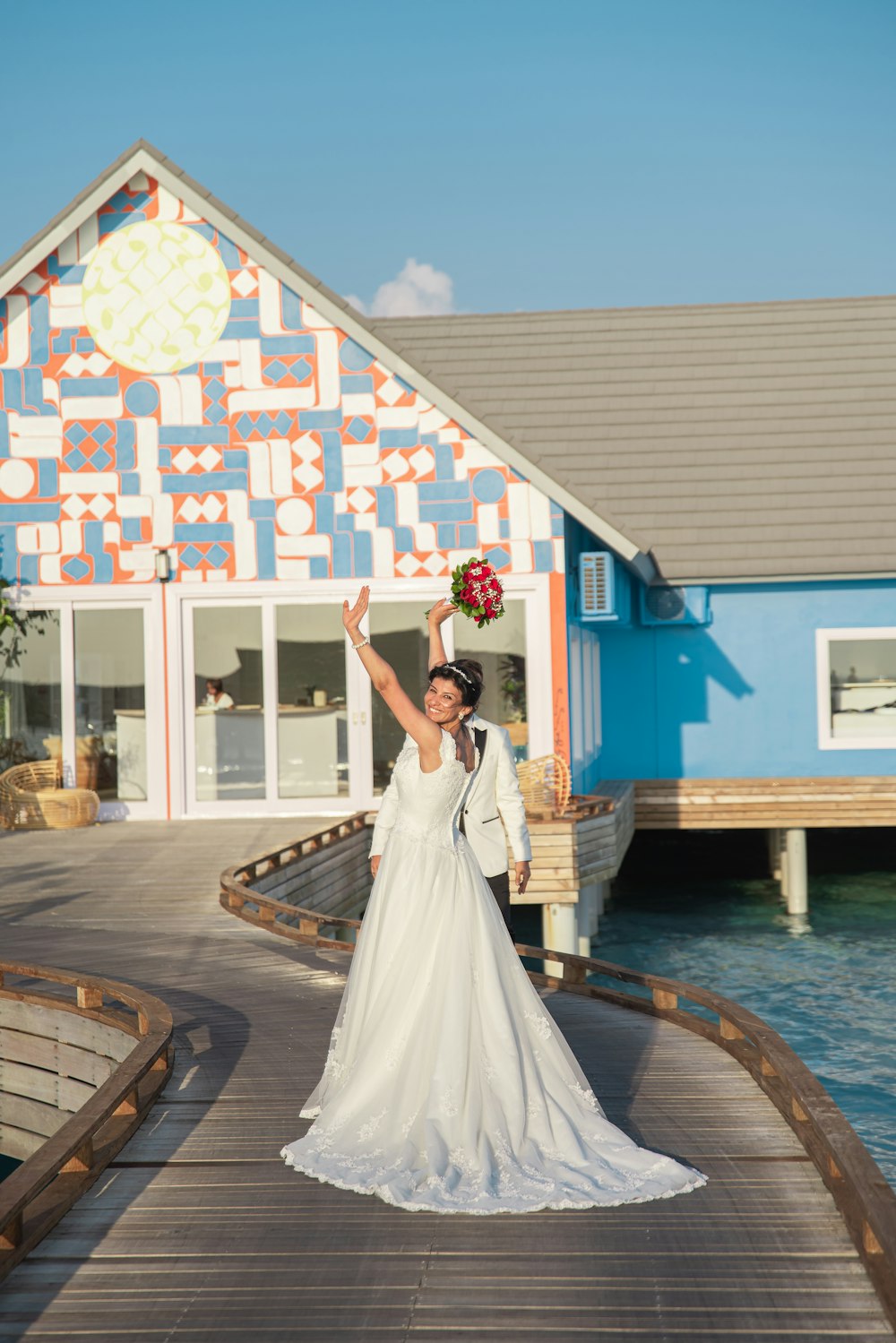 woman in white wedding dress standing on brown wooden dock during daytime