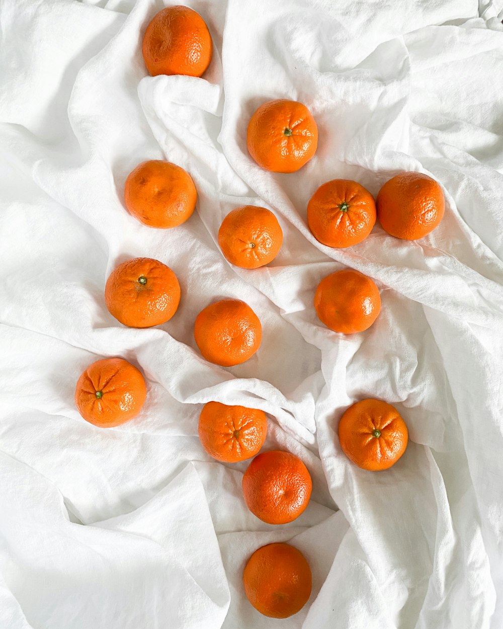 orange fruits on white textile