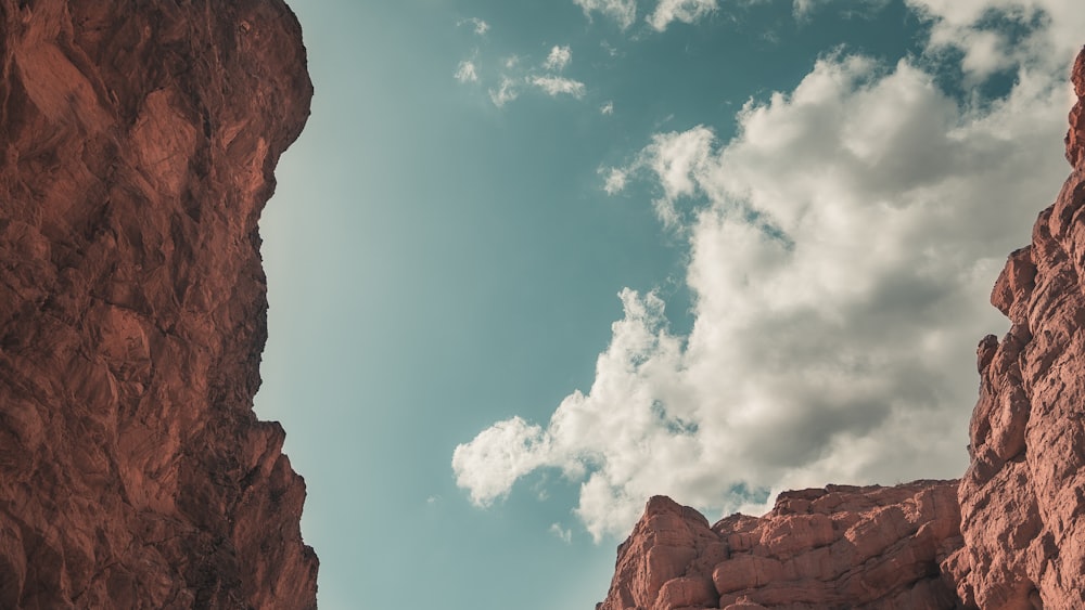 brown rock formation under blue sky and white clouds during daytime