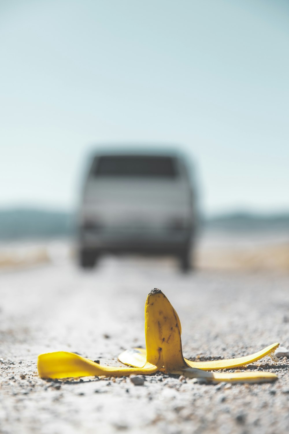 buccia di banana gialla su sabbia bianca durante il giorno