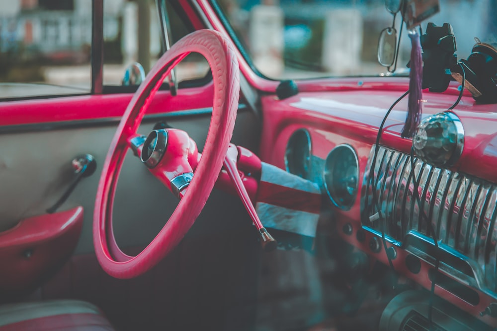 red car steering wheel in close up photography