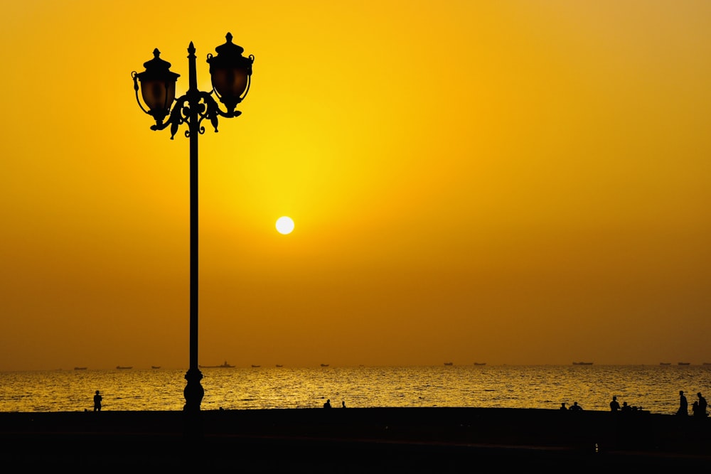 silhouette of lamp post during sunset