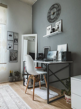 A clean, minimalist workspace with a vinyl art piece displayed prominently on a white wall.