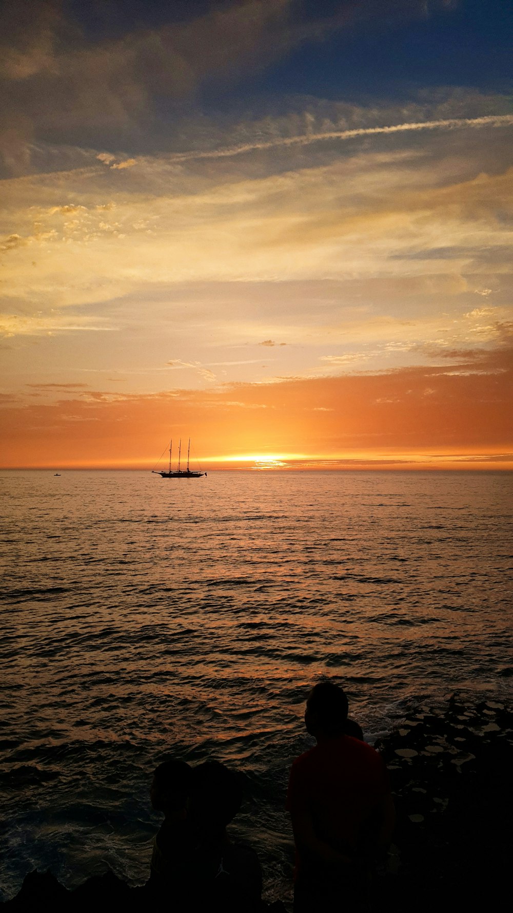 silhouette of boat on sea during sunset