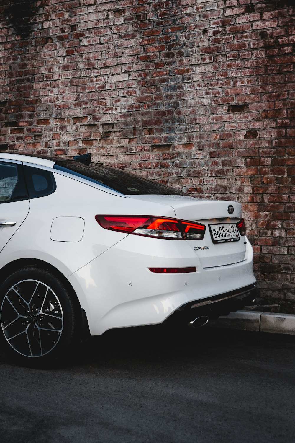 white bmw m 3 coupe parked beside brown brick wall