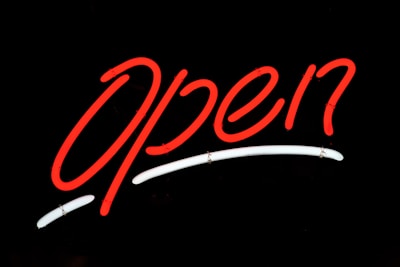 Close-up of a bold red and black illuminated sign glowing at night.