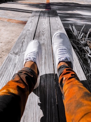 A pair of colorful tie dye pants laid out on a rustic table with natural light.
