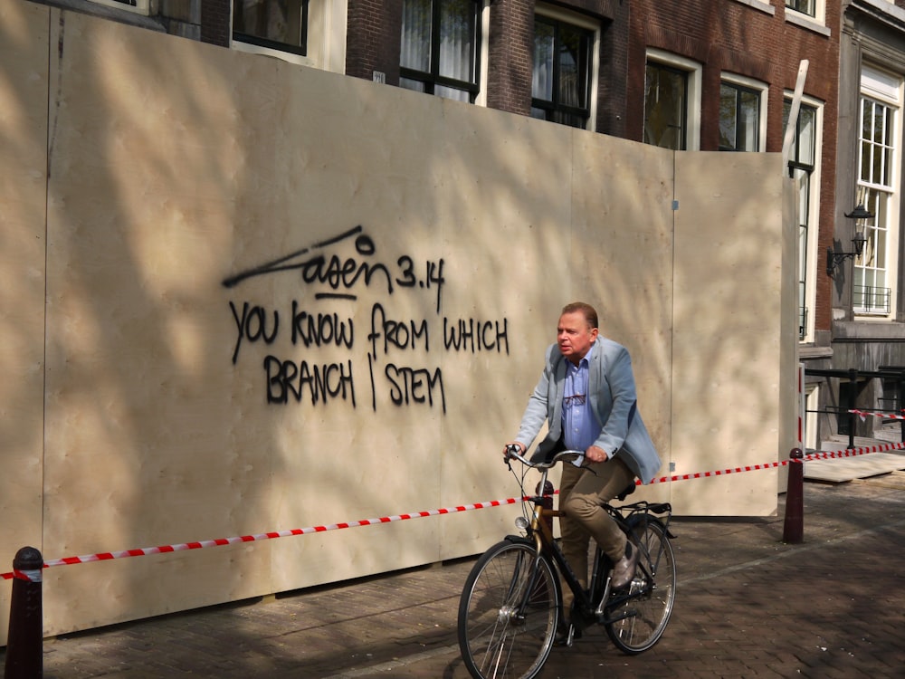 man in blue suit jacket and blue denim jeans riding on bicycle