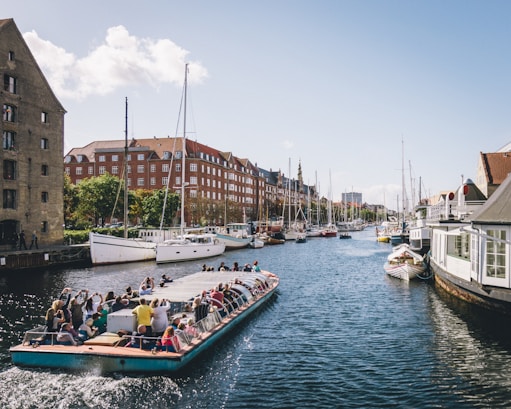 people riding on boat on water near buildings during daytime