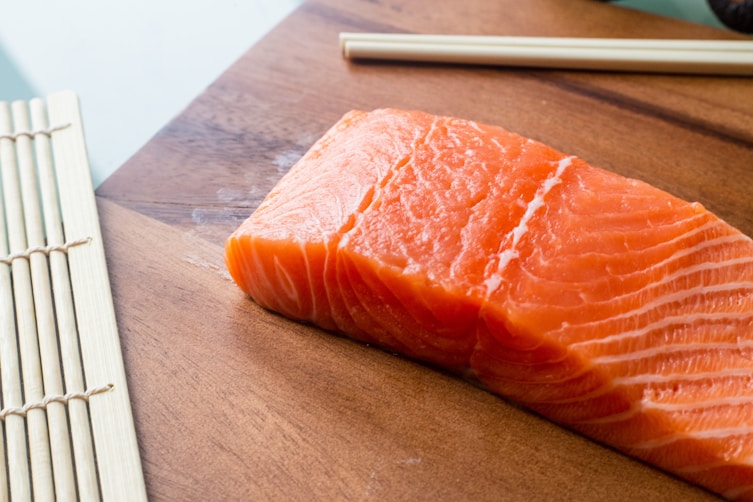 Wild caught sockeye salmon on a board with chopsticks rich in calcium vitamin D and omega 3s