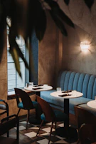 A cozy corner of a Scandinavian restaurant with deep blue cushions and soft natural light.