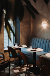 A cozy corner of the café with glowing purple ambient lighting and smooth glass surfaces.