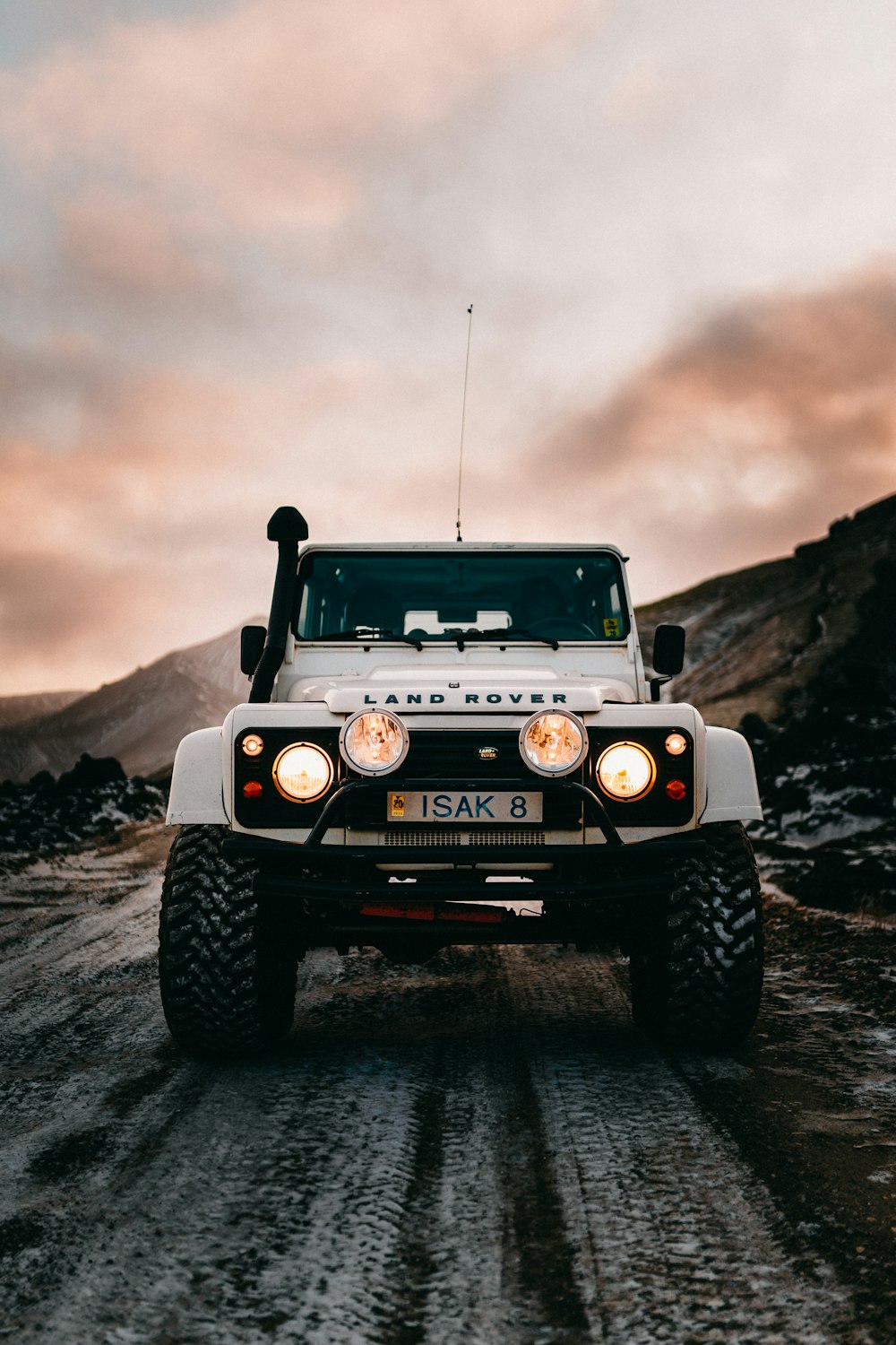 grayscale photo of black jeep wrangler on rocky hill