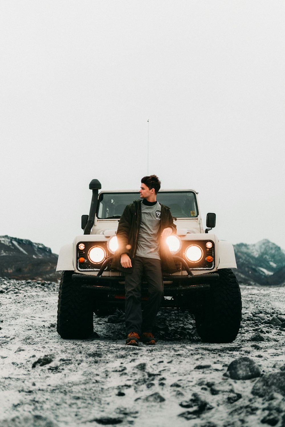 man and woman riding yellow jeep wrangler on snow covered ground during daytime