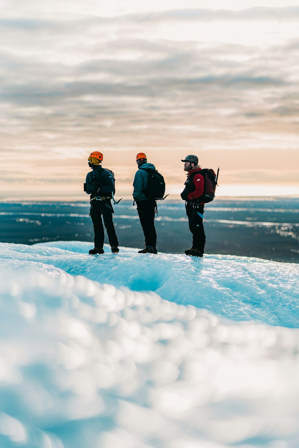 3 person standing on snow covered ground during daytime