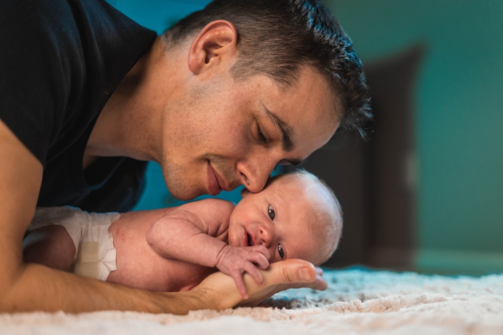 man in black shirt carrying baby