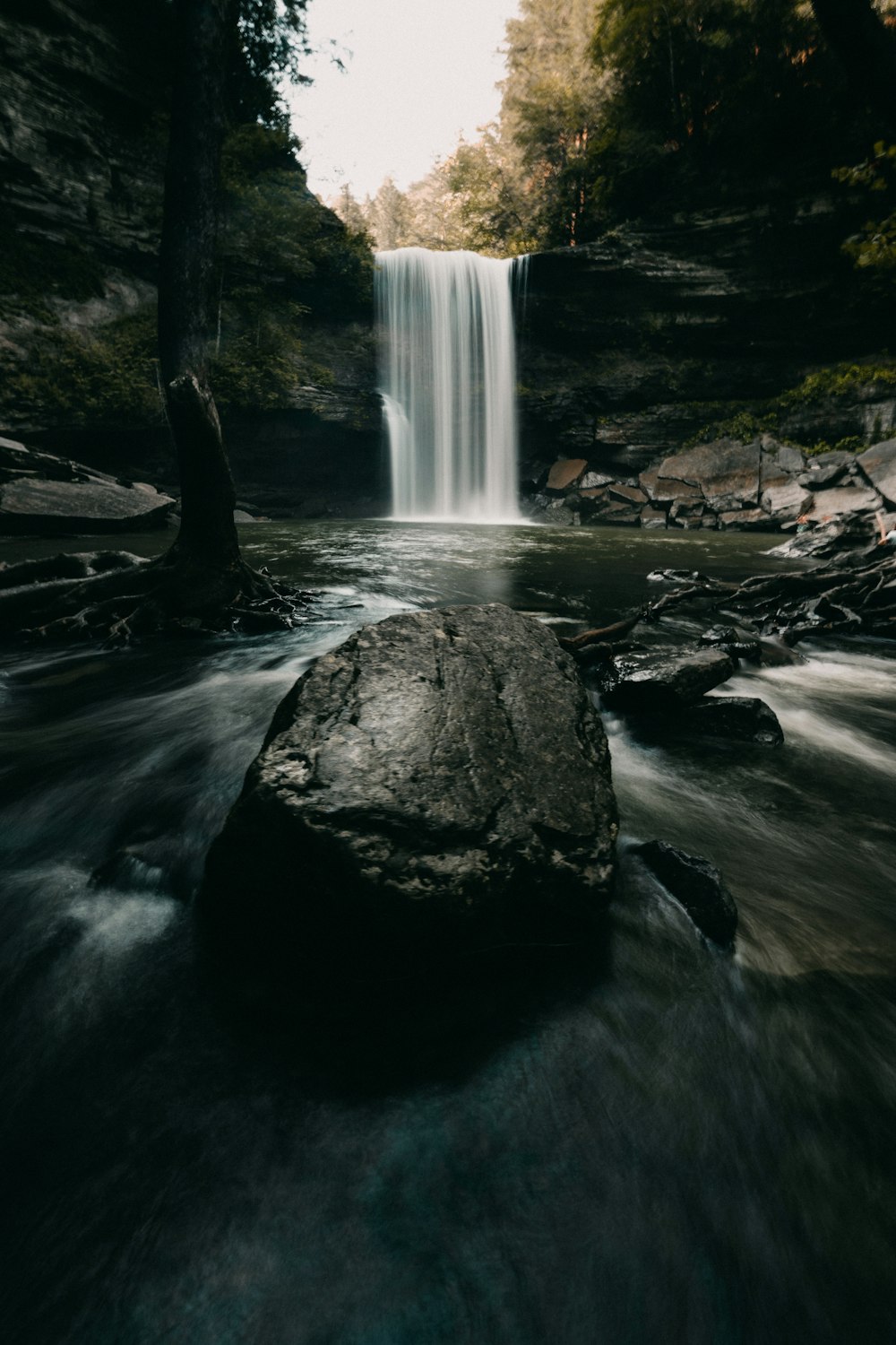 water falls on rocky shore during daytime