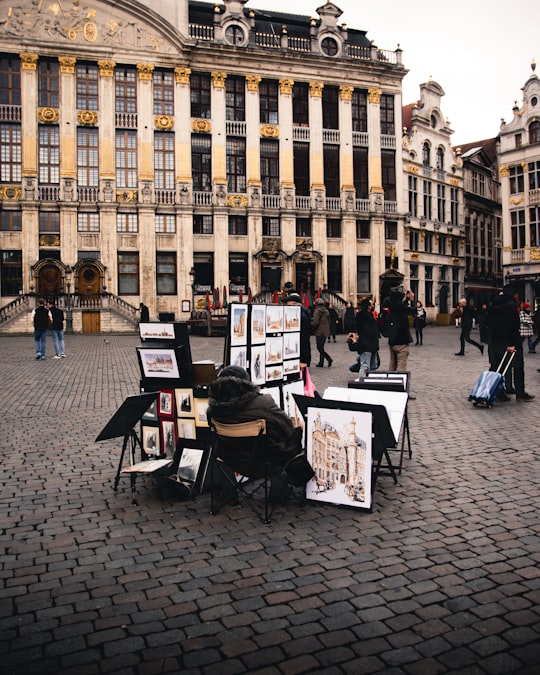 people sitting on chair in front of brown building during daytime in Grand Place Belgium